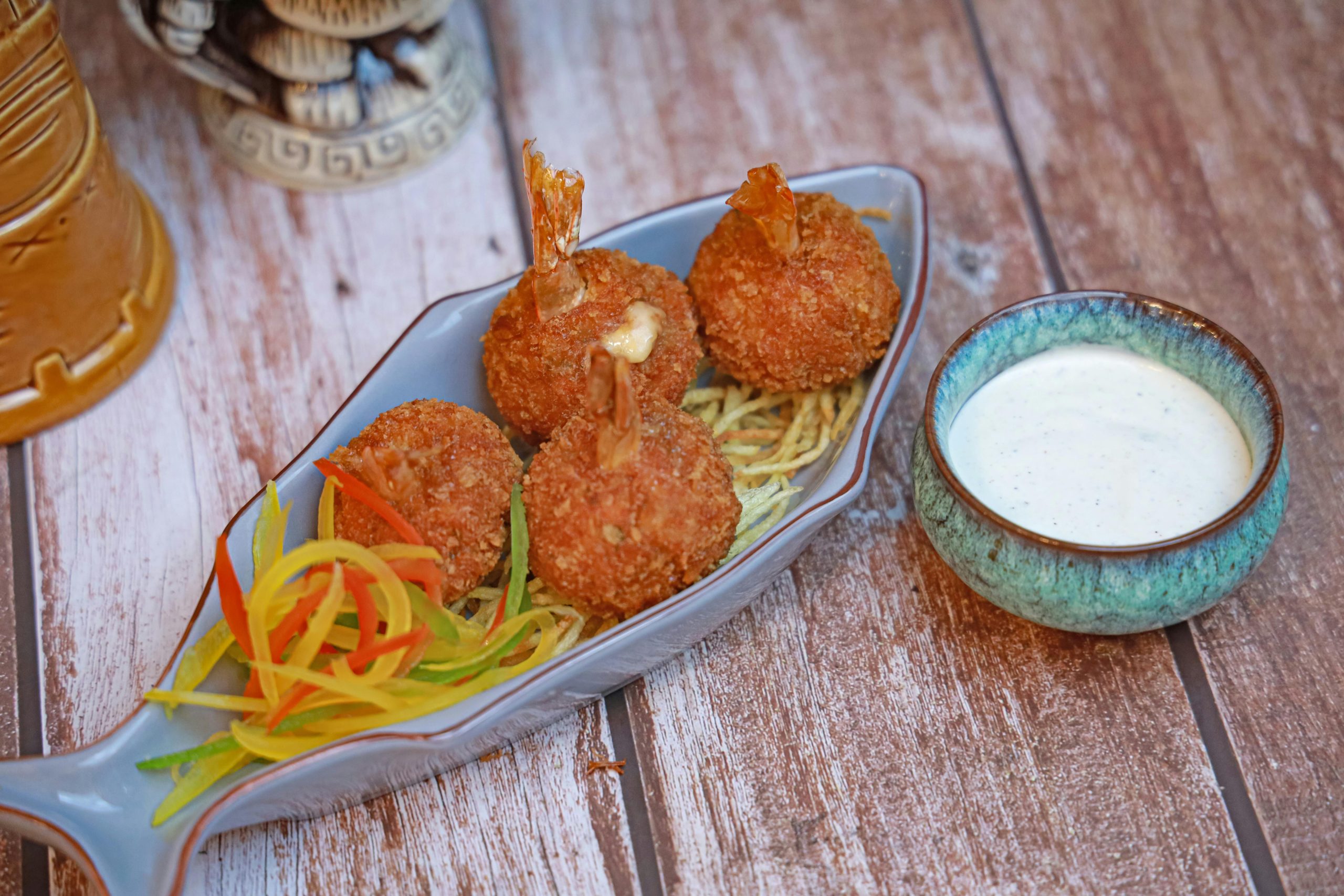 Delicious crispy shrimp balls served with a side of creamy sauce.